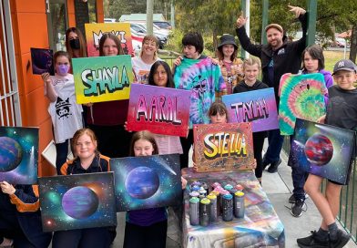 Crewative Arts Connect students show off their art work featuring their names and planets.